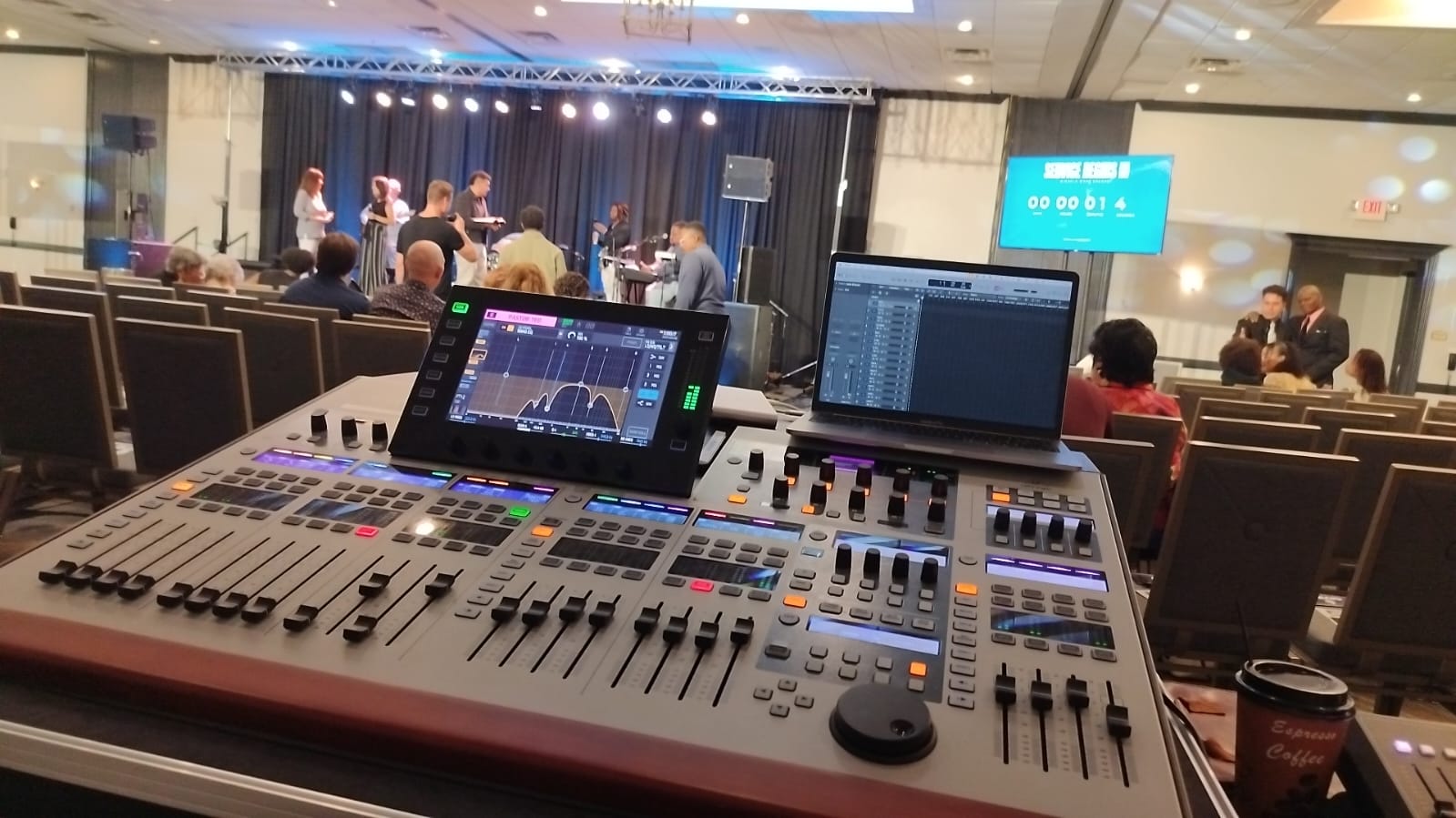 Digital mixing console running live church service with worship team on stage